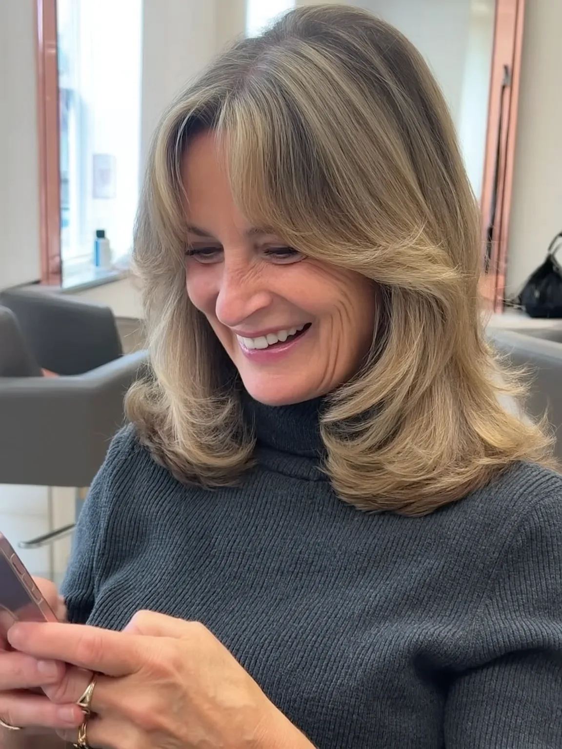 Voluminous Sandy Blonde Feathered Layers with Curtain Bangs